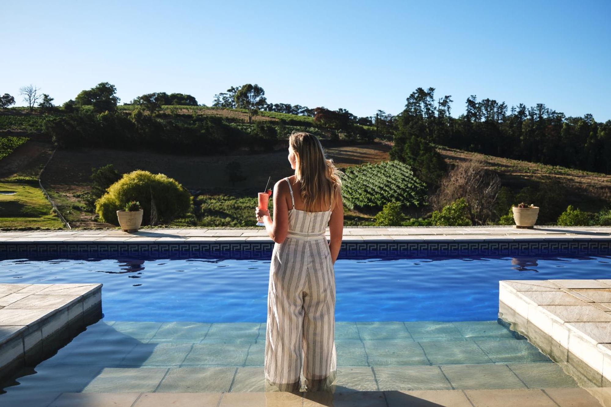 Alluvia Boutique Winery & Luxury Accommodation Stellenbosch Oda fotoğraf A woman standing by a pool